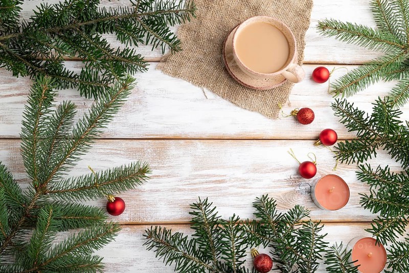 Christmas or New Year composition. Decorations, red balls, fir and spruce branches, cup of coffee, candles on a white wooden background. Top view, copy space, flat lay