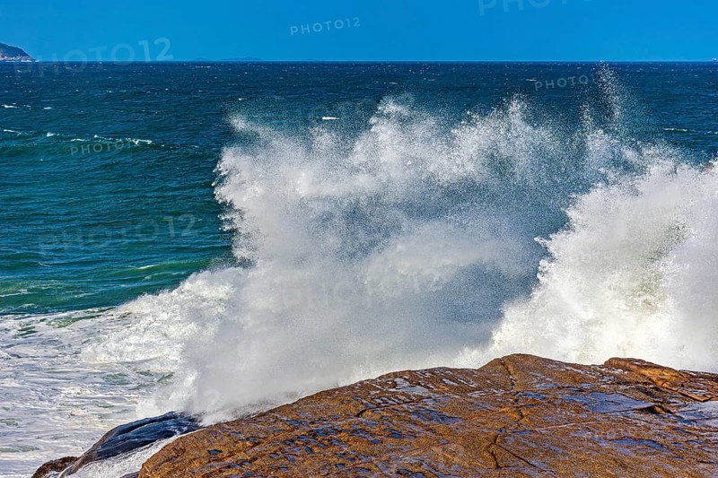 Sea water splashing after a wave crashes hard against the rocks on Ipanema beach in Rio de Janeiro, Ipanema Beach, Rio de Janeiro, Rio de Janeiro, Brazil, South America