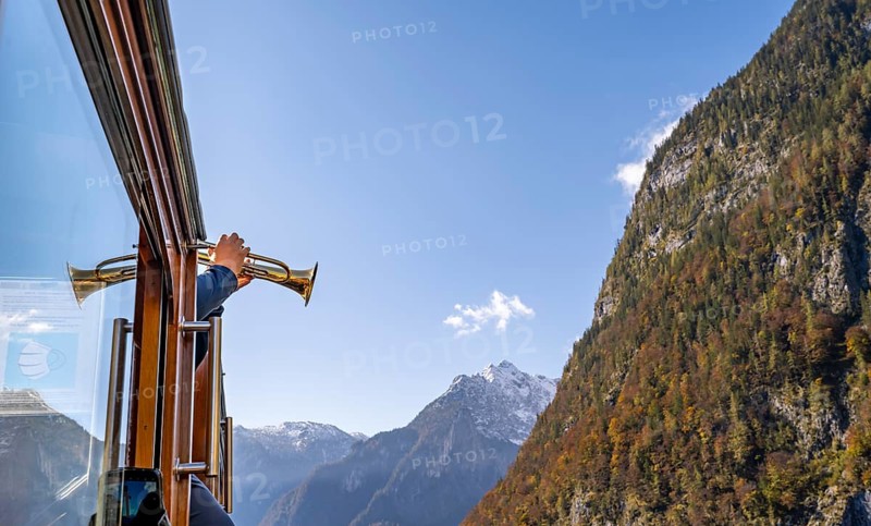 A trumpet is played on the echo wall of a tourist boat, Königssee, autumnal mountain landscape reflected in the lake, Berchtesgaden National Park, Berchtesgadener Land, Upper Bavaria, Bavaria, Germany, Europe