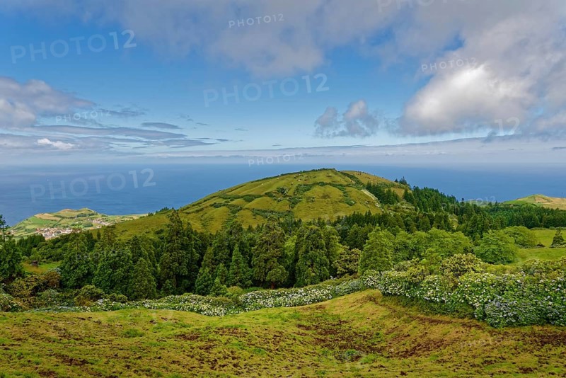 Distant view over green volcanic cones to the sea and clear sky, Caldeira das Sete Cidades, Sete Cidades, Sao Miguel Island, Azores, Portugal, Europe