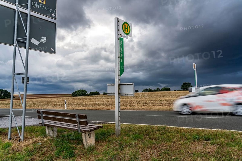 Single stop of bus line 510 between Korbach and Bad Wildungen, country road near Waldeck in North Hesse, bus stop Abzweig Netze, bus traffic between 6 a.m. and 5 p.m., NVV, Nordhessische VerkehrsVerbund, thunderstorm front approaching, Germany, Europe