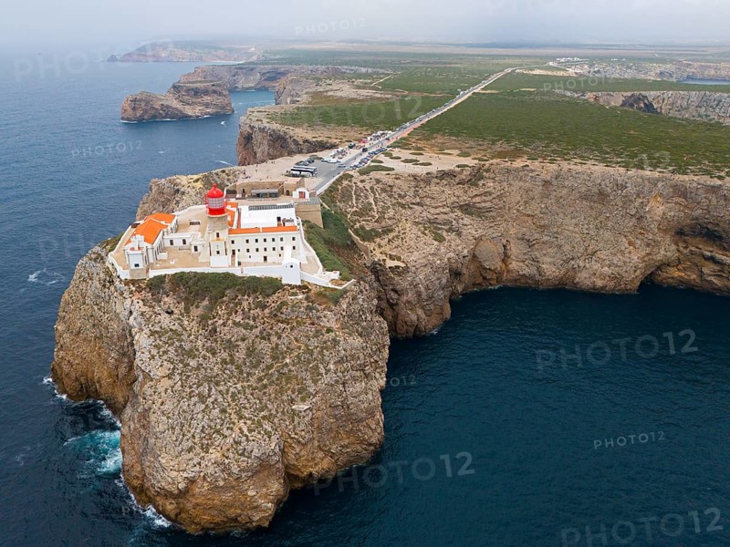 A remote lighthouse and several buildings stand on a cliff, with a wide view of the ocean and the surrounding area, aerial view, lighthouse, Cabo de São Vicente, Cape St Vincent, Cape St Vincent, Sagres, Portugal, Europe