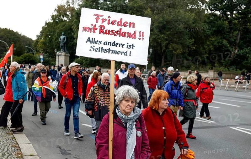 A demonstrator carries a placard with the inscription Peace with Russia during the demonstration Never again war, Berlin, 3 October 2024. The participants are against the stationing of US missiles in Germany, against the war in Ukraine and against German arms deliveries to Ukraine and Israel, Berlin, Berlin, Germany, Europe