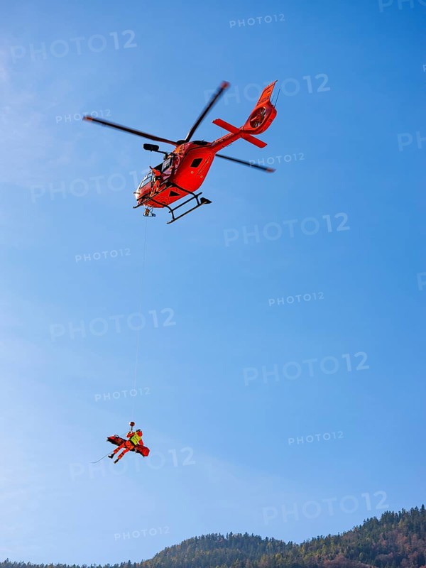 Injured person in a mountain bag with an air rescuer being winched into the rescue helicopter Christoph 14 with the cable winch, Bad Reichenhall, Berchtesgadener Land, Upper Bavaria, Bavaria, Germany, Europe