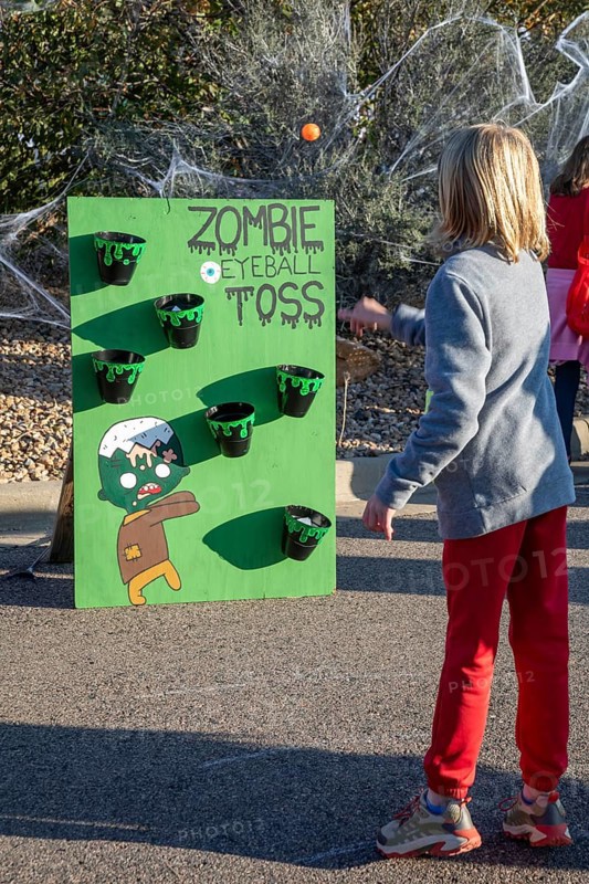 Lakewood, Colorado, Families enjoy the pre-Halloween Haunted Trail event at Bear Creek Lake Park. A girl competes in the zombie eyeball toss