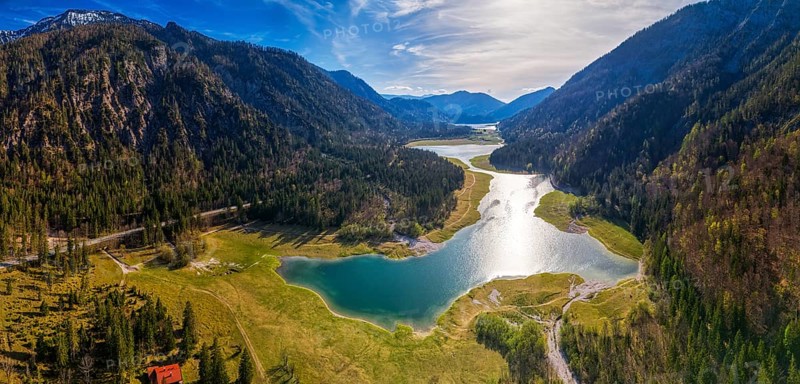 Mountain landscape with lake and forest, reflection of the sun in the water under a blue sky, Mittersee