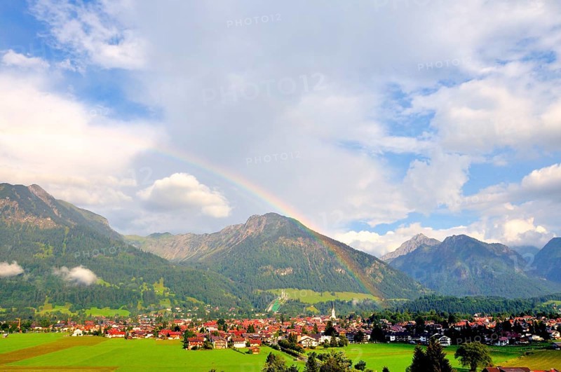 View over Oberstdorf with rainbow, behind it the Schattenberg with Schattenbergschanze, Oberallgäu, Bavaria, Germany, Europe