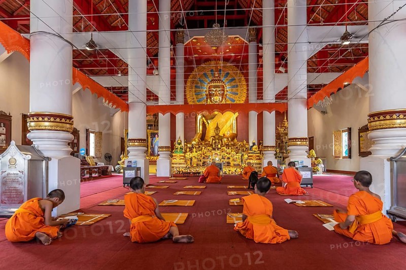 Monks and novices praying in the Buddhist temple Wat Phra Singh, Chiang Mai, Thailand, Asia