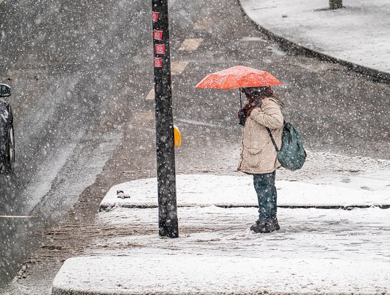 Winter weather, heavy snowfall, city centre traffic, Alfredstraße, B224, in Essen, person with umbrella waiting at traffic lights in snowstorm, North Rhine-Westphalia, Germany, Europe