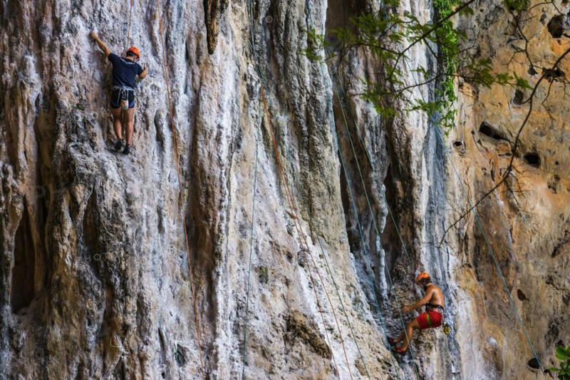 Rock climber at Phra Nang beach near Krabi, climber, outdoor, active holiday, climbing, rocks, chalk cliffs, sandstone cliffs, climbing, sport, sports holiday, rock climbing, height resistance, no fear of heights, courage, fear, overcoming fear, overcoming, extreme sportsman, extreme sport, safety, roping up, roped up, Thailand, Asia