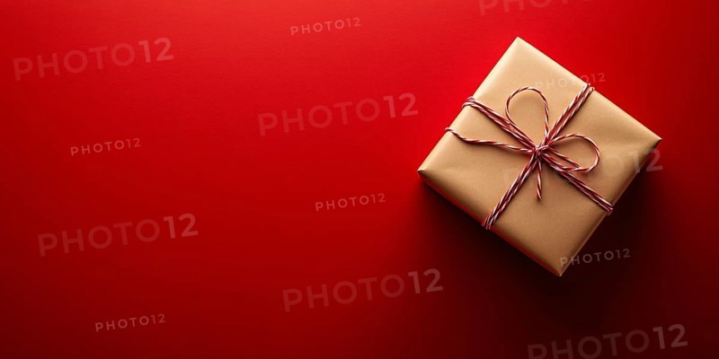Banner with small Christmas gift box wrapped in graft paper on red background with copy space. Generative Ai, AI generated
