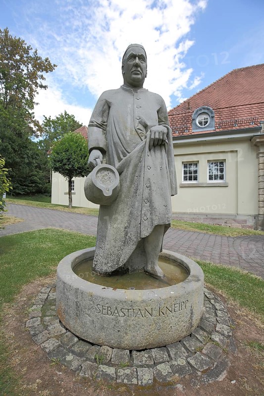 Monument to Sebastian Kneipp 1821-1897 in the water basin with jug, man, sculpture, water, carry, town hall, Gersfeld, Hesse, Rhön, Germany, Europe