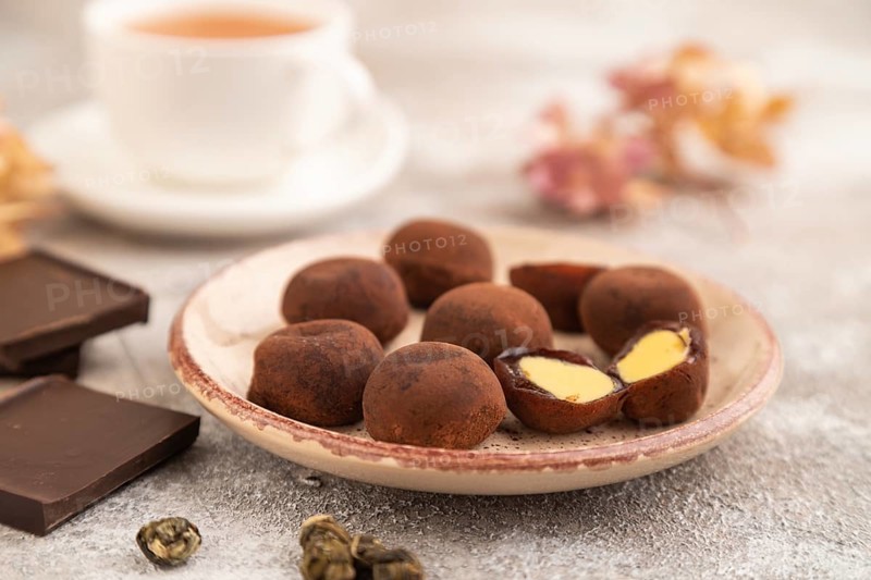 Japanese rice sweet buns chocolate mochi filled with cream and cup of green tea on brown concrete background. side view, close up, selective focus