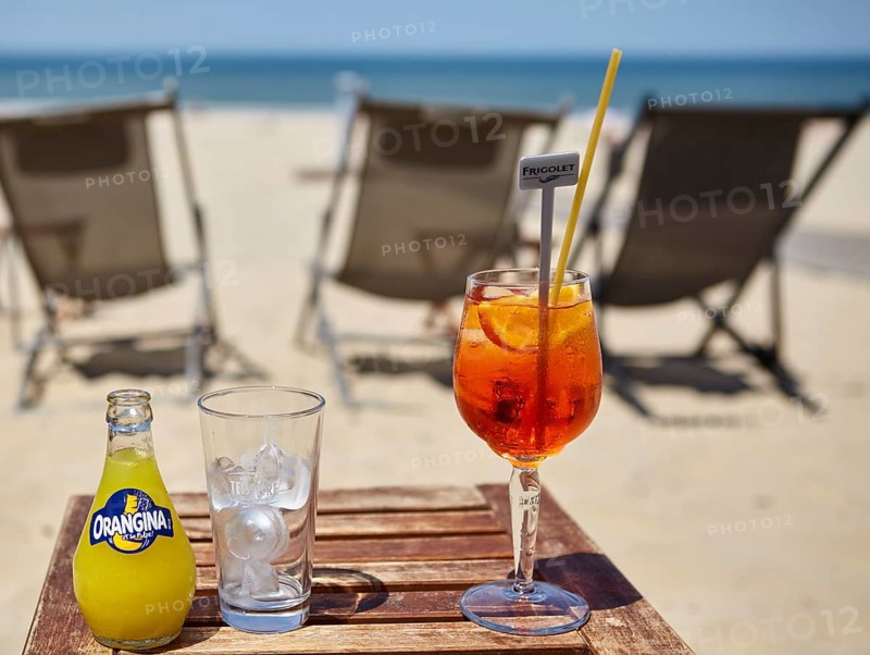 A bottle of Orangina, a glass with ice cube cubes and a glass of Aperol Spritz with a straw in a beach bar in Soulac-sur-Mer, Gironde, Nouvelle-Aquitaine, France, Europe