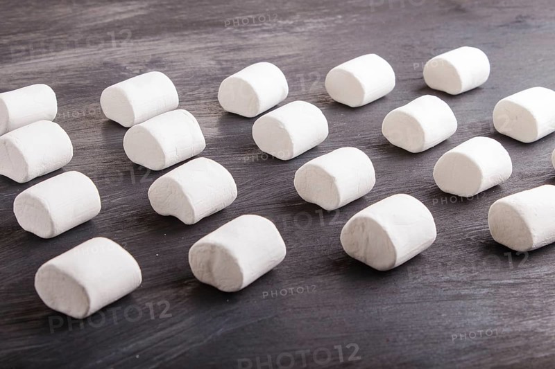 Set of marshmallows on black wooden background. top view, flat lay. geometric pattern