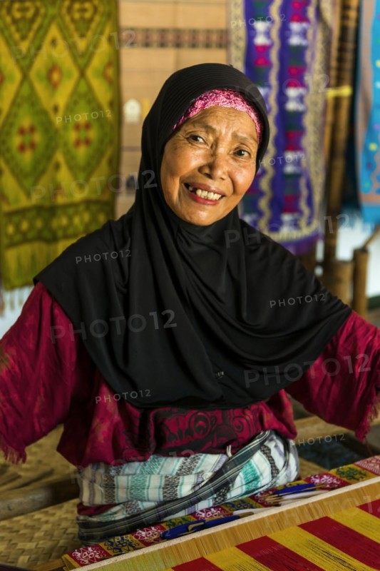 Traditional weaver, weaving, woman's work, working conditions, loom, textile, woman, trade, bazaar, authentic, fabric, fabric pattern, craft, handicraft, Asian, indigenous, tradition, traditional, marketplace, travel, tourism, culture, poverty, presentation, lifestyle, person, Muslim, Islam, Sasak, indigenous, indigenous people, cultural heritage, silk weaving, portrait, human, Sade village, Lombok, Indonesia, Asia