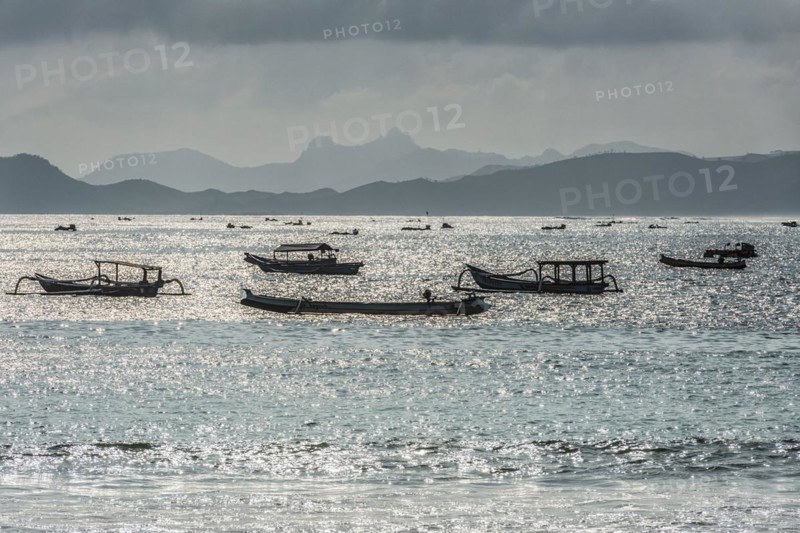 Evening mood on the beach of Kuta, water, sea, ocean, swimming, beach holiday, holiday, travel, holiday mood, silhouette, fishing boat, boat, reflection, sunlight, summer, sun, glittering water, silhouette, backlight, light mood, mountains, mountainous, paradise, holiday paradise, holiday dream, long-distance travel, holiday destination, haze, misty, coast, beach holiday, serenity, tranquility, emotion, Lombok, Indonesia, Asia