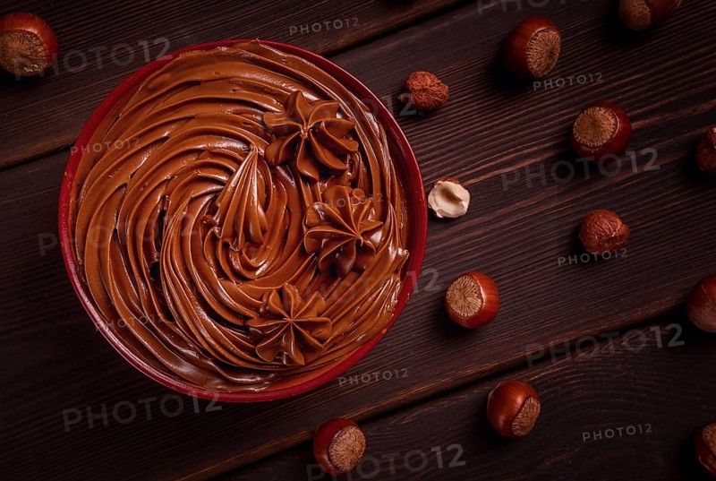 Chocolate nut paste, mousse, pasta, in a cup, on a wooden table, top view, selective focus, no people