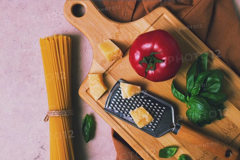 Raw pasta with ingredients on a beige background, top view, rustic style, selective focus, no people