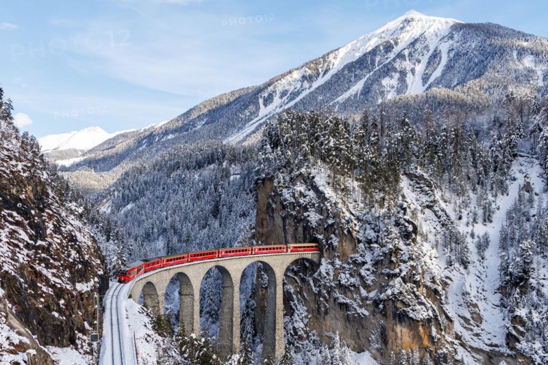 Rhaetian Railway train at the famous Landwasser Viaduct on the Albula railway Stadler Rail passenger train in the Alps in Filisur, Switzerland, Europe