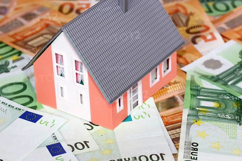 Concept photo with model house, euro notes and coins