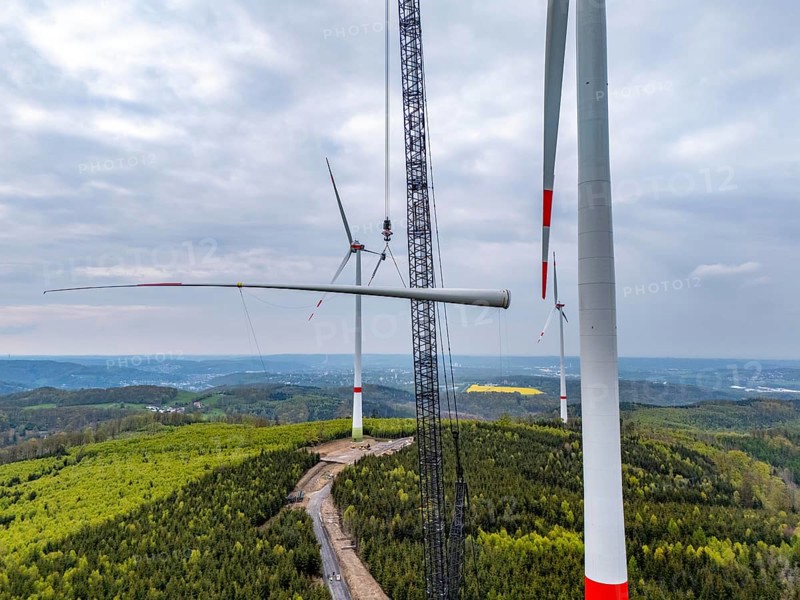 Erection of a wind turbine, wind energy plant, assembly of the third blade, with a crawler lattice crane, wind farm near Hagen, North Rhine-Westphalia, Germany, Europe