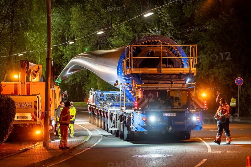 Transport of a 68 metre long, 22 tonne blade of a wind turbine, here in Schwelm, with a self-propelled Blade-Lifter vehicle, over a 40 km long route, over 2 nights, in the Bergisches Land, through towns, villages, over country roads, narrow through roads, to the construction site of the wind turbine near Hagen, North Rhine-Westphalia, Germany, Europe