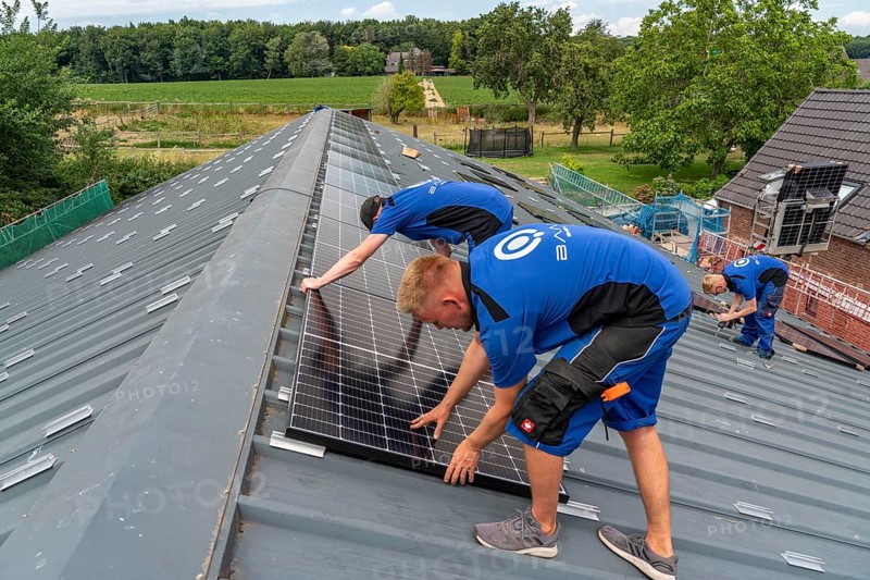 Installation of solar modules on the roof of a barn on a farm, over 240 photovoltaic modules are installed on the roof, North Rhine-Westphalia, Germany, Europe