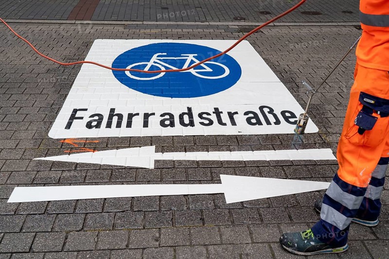 Application of road markings for a cycle lane, Rüttenscheider Straße in Essen, in the shopping and gastronomy district, cyclists have right of way over motorised vehicles, part of a cycle axis through Essen's city centre