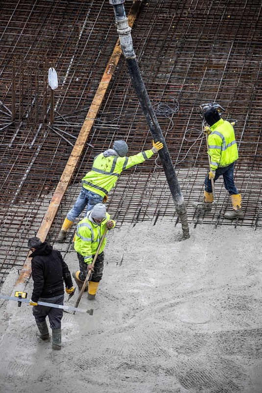 Construction site, concreting, the foundation of a building is concreted, the concrete is pumped onto the reinforced concrete mats