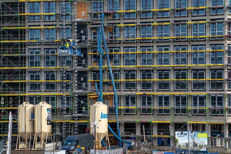 Large construction site, scaffolded shell of an office building complex, air hoses for construction ventilation, heating, construction lift, O-Werk Campus in Bochum, North Rhine-Westphalia, Germany, Europe