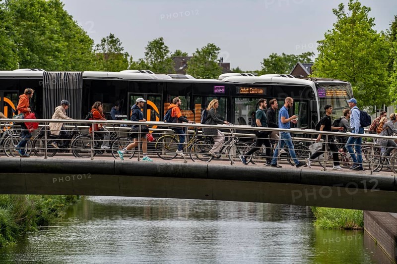 Central cycle path on the Vredenburgviaduct, public transport bus, at the Hoog Catharijne shopping centre, in the city centre of Utrecht, dense traffic, canal, Netherlands