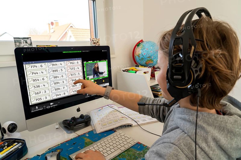 Young, primary school pupils, home learning, doing schoolwork, distance learning, virtual classroom, chat with teachers and classmates, home schooling, at home on the computer, effects of the corona crisis in Germany