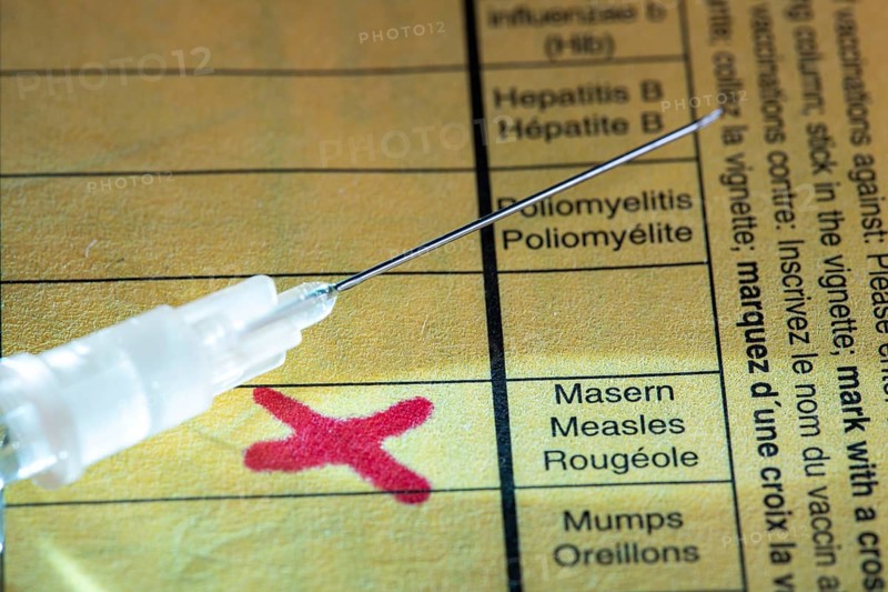 Symbolic photo measles vaccination, vaccination certificate, syringe with measles vaccine