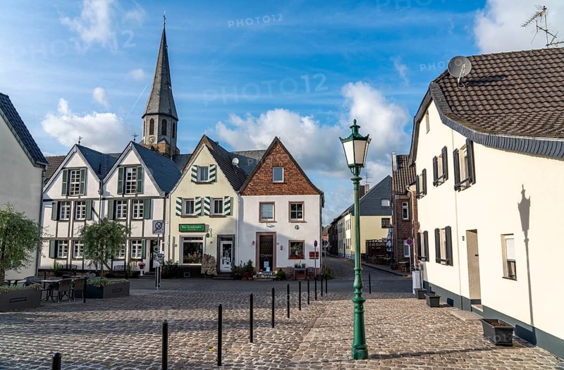 The village of Zons on the left bank of the Lower Rhine, former fortified zone, belongs to Dormagen, houses on Schlossstraße, church tower, St Martinus, North Rhine-Westphalia, Germany, Europe