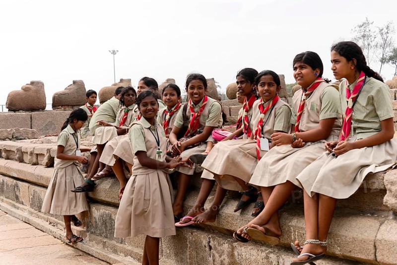 School class visiting the coastal temple of Mahabalipuram, Mamallapuram, Mahabalipuram, Tamil Nadu, A group of girls in uniforms smiling and taking a break in the open, Mahabalipuram, Tamil Nadu, South India, India, Asia