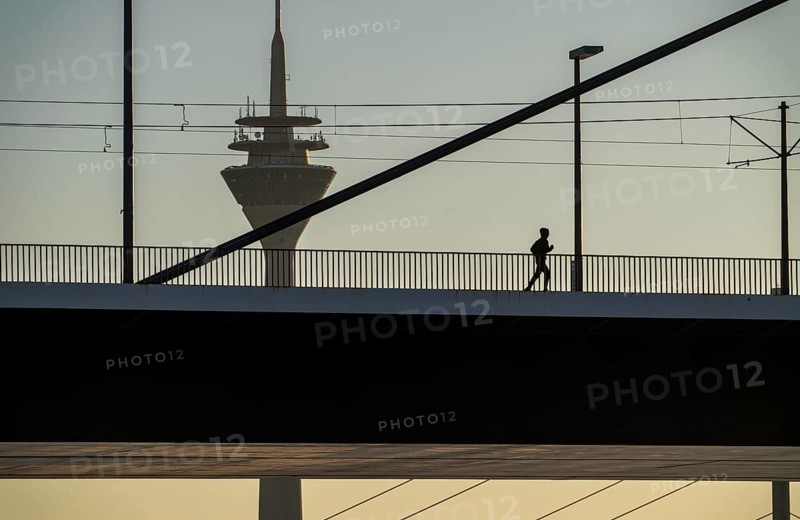 Jogger on the Oberkassler Rhine Bridge, Rhine Tower, behind the Rheinknie Bridge, Düsseldorf, North Rhine-Westphalia, Germany, Europe
