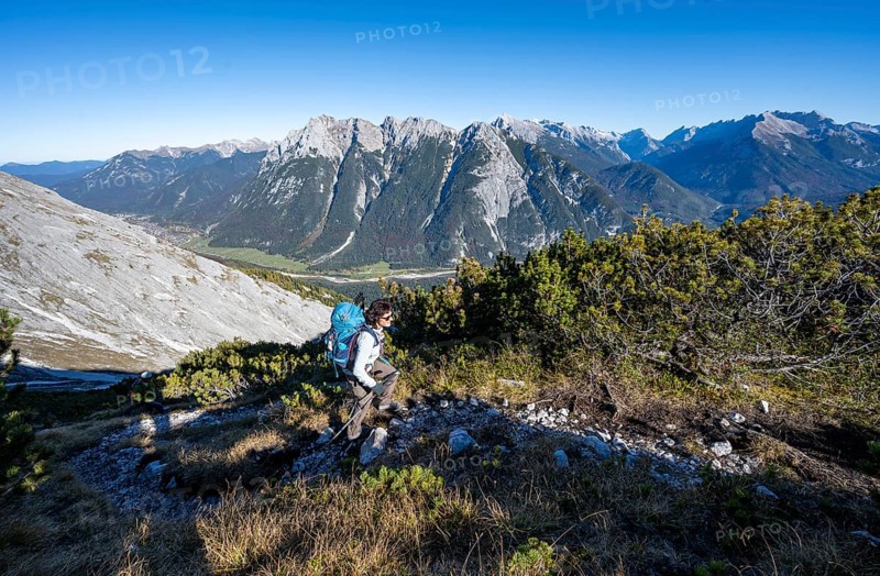 Mountaineer on a hiking trail, autumnal mountain landscape, ascent to the Große Arnspitze, view of mountain peaks of the Karwendel, near Scharnitz, Bavaria, Germany, Europe