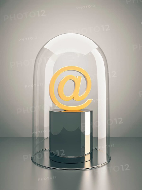 A golden email sign under a glass dome