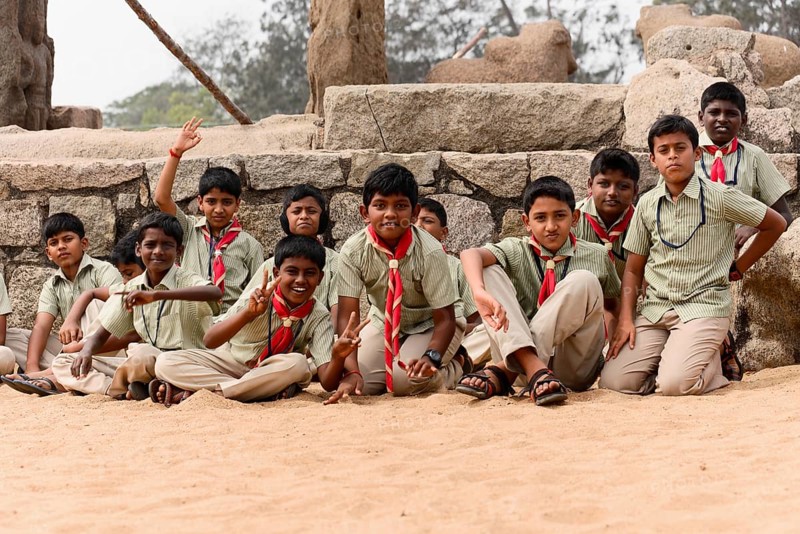 School class visiting the coastal temple of Mahabalipuram, Mamallapuram, Mahabalipuram, Tamil Nadu, A group of boys in uniforms play laughing in the sand, Mahabalipuram, Tamil Nadu, South India, India, Asia