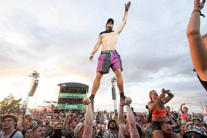 A festival visitor stands on the hands of two people during the performance of the band Feine Sahne Fischfilet at the Highfield Festival on Saturday, Störmthaler See, 17/08/2024