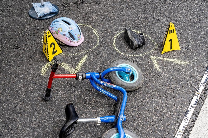 Markings at an accident scene with a balance bike for children, helmet, reenacted accident recording, at a public event organised by the Cologne police, symbolic image