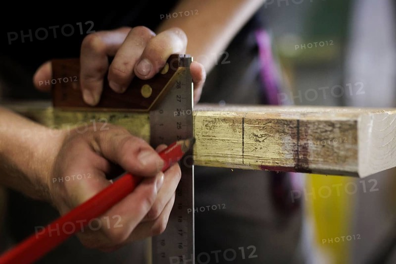 A man tears a section on a piece of wood. Berlin, 14.08.2024