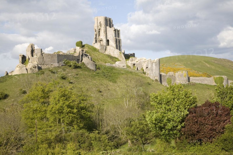 Corfe Castle is located in a natural defensive site on a hill between chalk ridges and for a thousand years has guarded the entry into the Isle of Purbeck. The ruined state of the castle date from the English Civil War when it was twice held siege in the 1640s and subsequently largely demolished