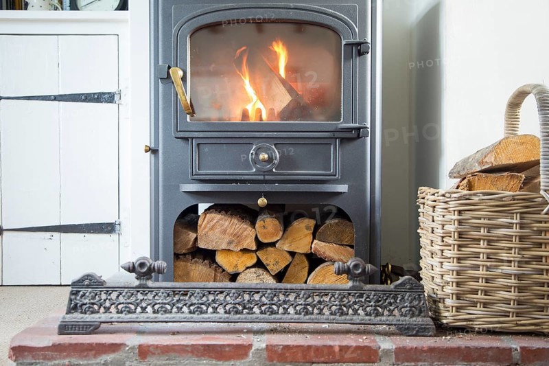 Warm fire flames logs burning in ClearView domestic multifuel stove burner inside home, UK