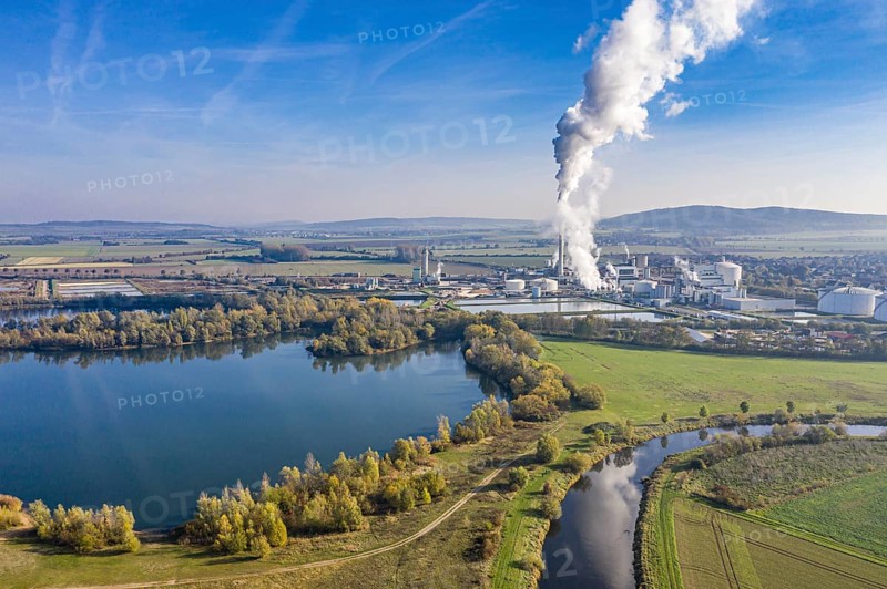 Drone shot of river Leine with Nordzucker sugar factory in Nordstemmen, smoking chimneys on a cold and sunny day, Germany, Europe