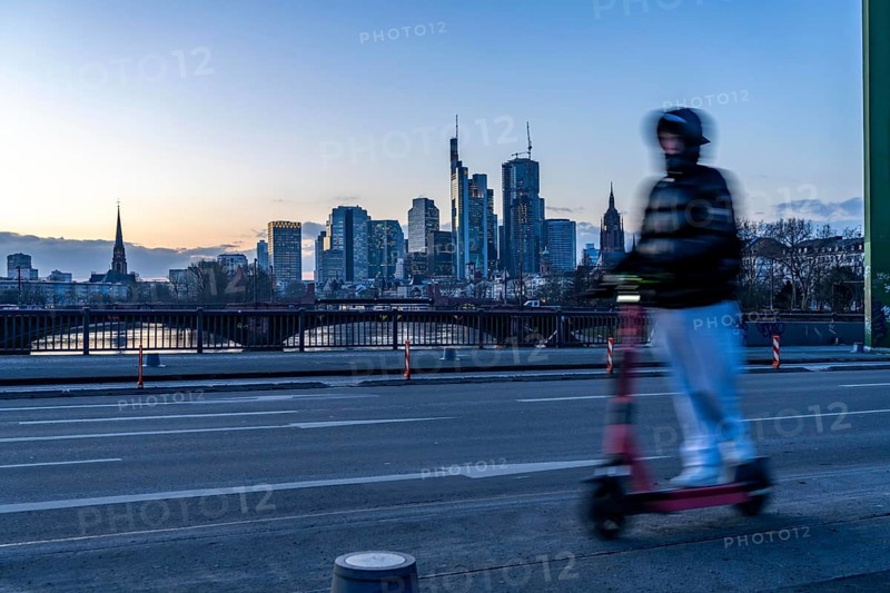 Skyline of the city centre of Frankfurt am Main, e-scooter on the raft bridge, dusk, river Main, winter, Hesse, Germany, Europe