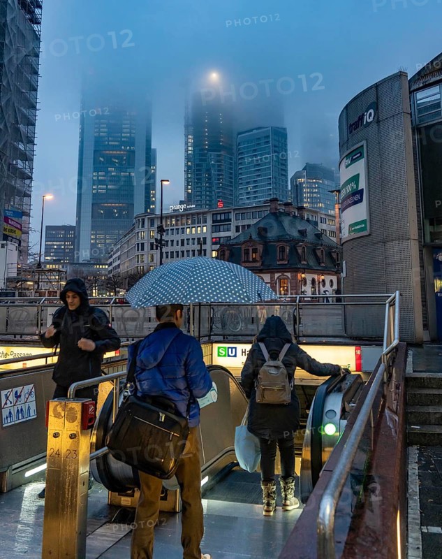 Rainy weather, freezing rain, entrance to Hauptwache underground station, high-rise skyline in clouds, passers-by hurrying through the damp, icy weather, Frankfurt am Main, Hesse, Germany, Europe