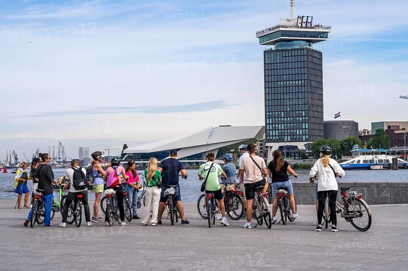 Sightseeing by bike, guided bike tour, here at the river Ij, view of A'DAM Lookout, building with the show This is Holland, Amsterdam, Netherlands