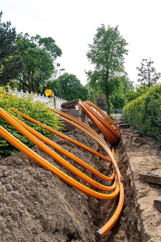 Laying of fibre optic cables, empty conduits are laid under a pavement, in which the actual fibre optic cable is later blown in and connected to the respective house connection or distributor. Essen, North Rhine-Westphalia, Germany, Europe